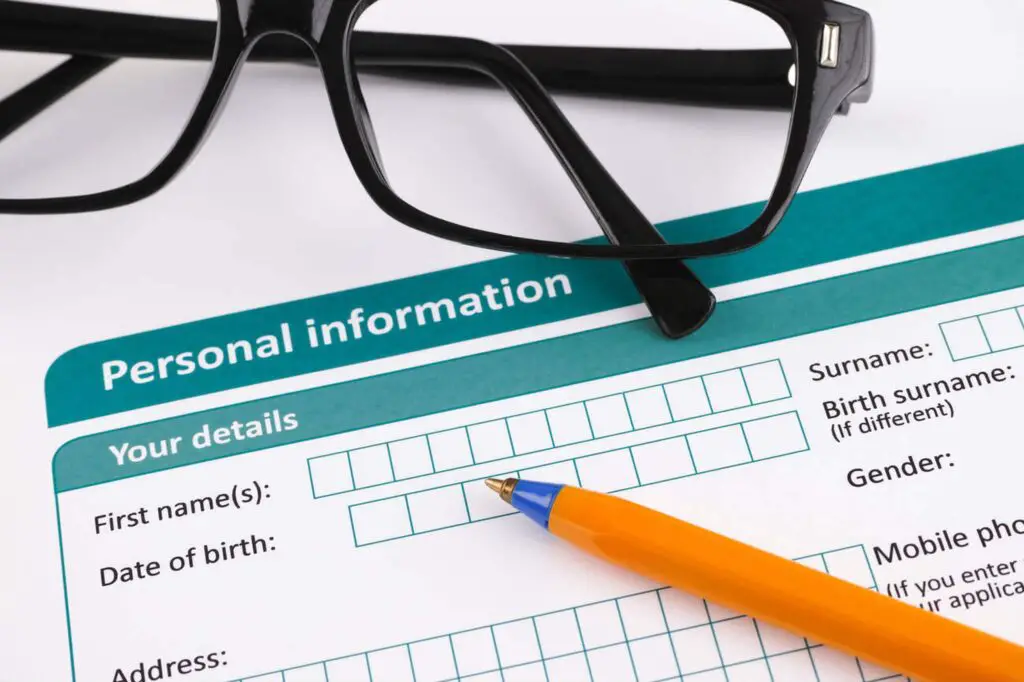 Personal information form with ballpoint pen and glasses